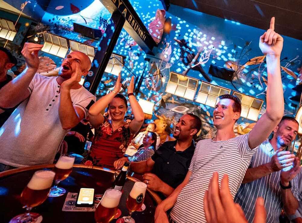 Collega's lachen tijdens bedrijfsuitje met QuizX pubquiz op locatie