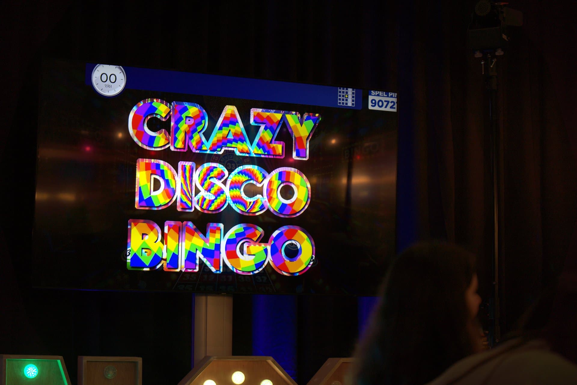 Disco bingo - Een scherm toont de tekst 'CRAZY DISCO BINGO' in regenboogkleuren, met een timer en spelcode zichtbaar. De...