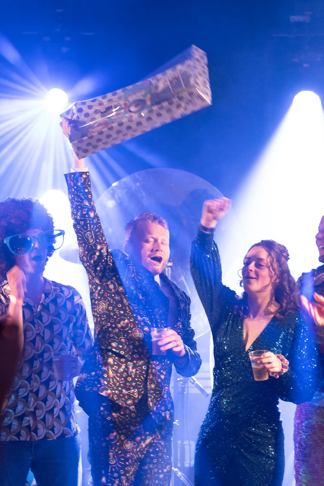 Winnaar houdt bingokaart omhoog tijdens een disco bingo avond van QuizX