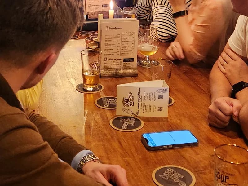 Pubquiz met quizmaster - Twee deelnemers kijken naar een groot scherm tijdens een quiz, waarbij de vraag is wie als eerste een CE-logo...