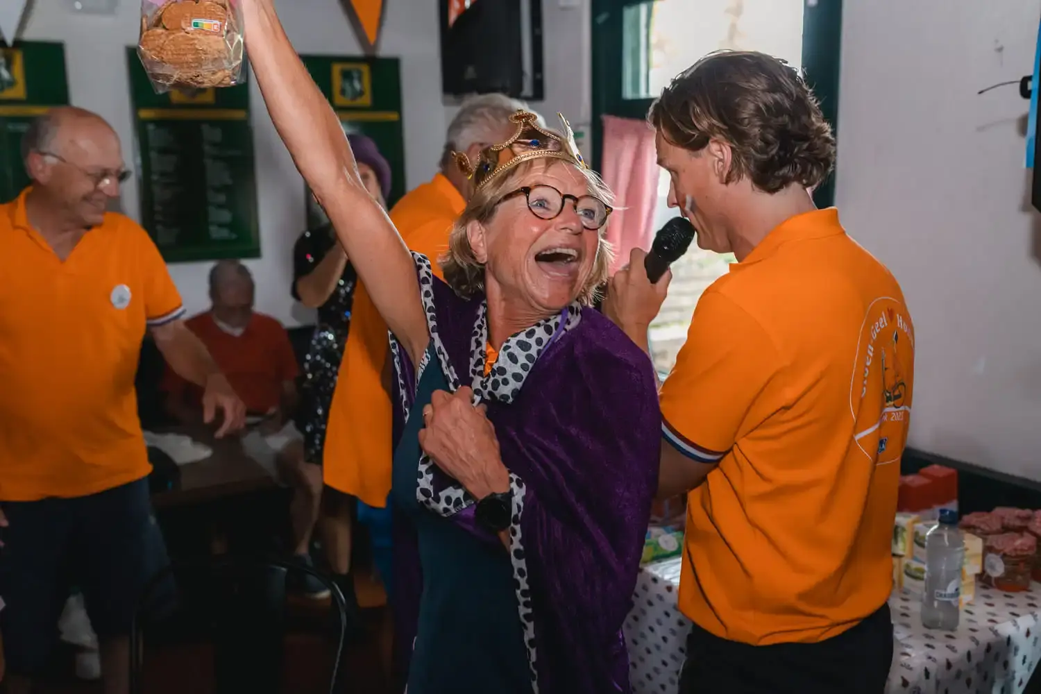 Vrouw viert overwinning tijdens Ik hou van Holland in oranje kleding.